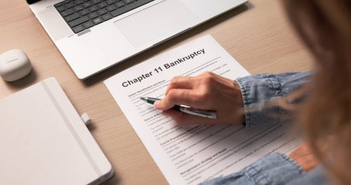 Worried Woman Fills Out Bankruptcy Forms At Home