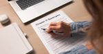 Worried Woman Fills Out Bankruptcy Forms At Home