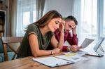 Young couple feeling worried while trying to get their finances in order