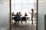 Silhouettes of businesspeople gathered in conference room, blurred view